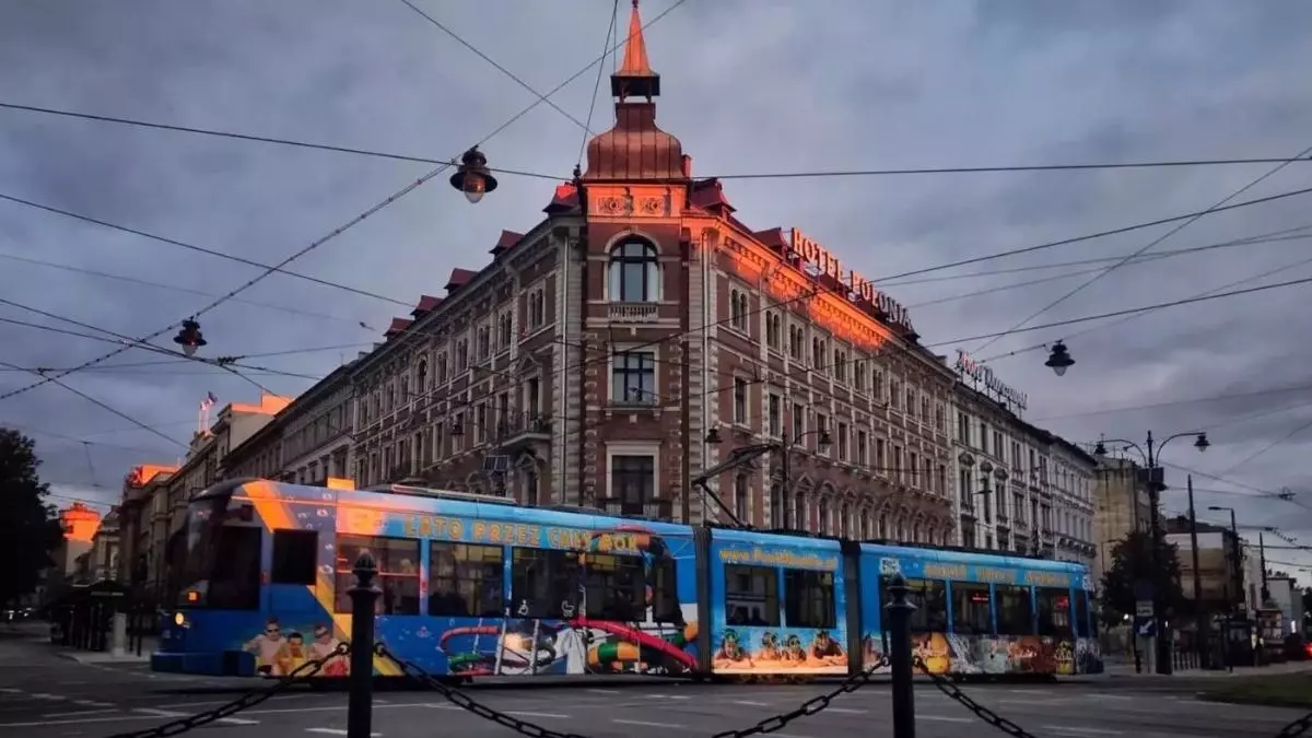 Image of a Train passing by in front of old building on the Poland photography tour